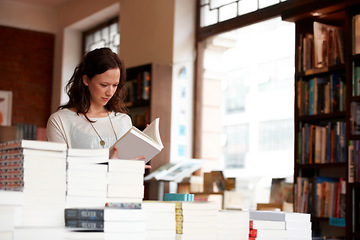 Image showing Woman, books and reading in a store, library or bookstore customer and choosing a novel to buy, read or study. Girl, bookshelf and studying a book for college, university or research information