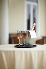 Image showing Hotel, bottle and glasses of champagne on a table for luxury service, celebration and hospitality. Restaurant, wealth and wine, alcohol and drinks at a fine dining establishment for an experience