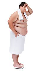 Image showing Body, plus size and man on a scale in studio with stress or frustration after diet or exercise failure. Upset, weight loss and male person with towel weighing on machine isolated by white background.