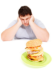 Image showing Sad, plus sized and man with a burger meal in a studio for lunch, supper or dinner for weight gain. Depression, upset and male person with fast food with calories isolated by a white background