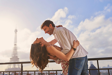 Image showing Love, Paris and couple together for a kiss, romantic time or balcony of apartment, hotel with Eiffel Tower in background. Partner, woman and man in France for vacation, travel or honeymoon holiday