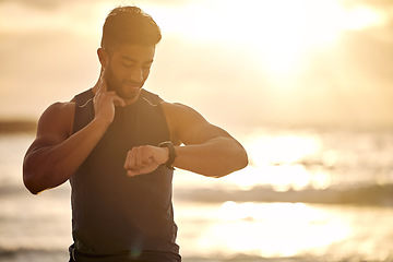 Image showing Sunset, beach and man with smart watch for heart rate tracker, fitness and workout in nature. Exercise, ocean and runner mobile app checking pulse or time on stopwatch in silhouette with mockup space