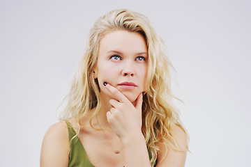 Image showing Young woman, thinking and decision in studio with ideas, memory and focus by gray background. Girl, model and think with concentration, remember and confused for choice, planning or question on mind