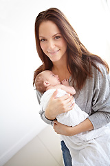 Image showing Mother, portrait and holding newborn in family home with love, happiness or care with smile. Young mom, infant child or baby with happy bonding, pride or hug together with blanket in morning at house