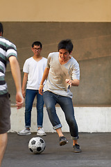 Image showing Friends in city street, man with football for sports, fun and happy energy with urban games in Korea. Game, friendship and group of young Asian men running in road with soccer ball for weekend time.