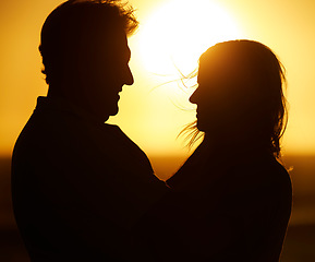 Image showing Silhouette, couple and love at sunset on beach for vacation, holiday or adventure outdoor in nature. Romantic man and woman in marriage with sky background for care, shadow art and travel freedom