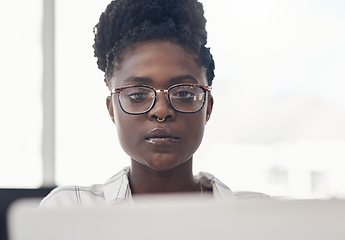 Image showing Black woman, entrepreneur and focus on computer at the office for online search for business. Professional female, tech and working with serious face for a project on the internet for a start up.