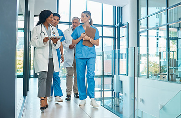 Image showing Hospital, doctors and nurses team walking with a tablet for a discussion, planning or research. Diversity men and women healthcare group talking about medical strategy, virus or surgery schedule