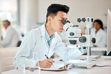 Image showing Science, notebook and microscope with an asian man doctor working in a lab for research or innovation. Healthcare, medical and writing with a male scientist working in a laboratory for analysis