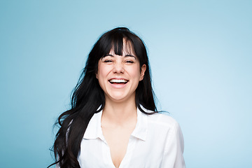 Image showing Smile, laughing and portrait of a beautiful woman isolated on a blue background in a studio. Happy, young and a headshot of a girl in a shirt with confidence, empowerment and looking stylish