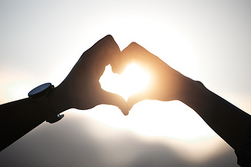 Image showing Heart hands of couple at sunset, emoji in silhouette and nature to celebrate marriage, date or honeymoon. Summer, travel and vacation sun, love hand sign with man and woman together in relationship.