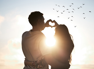 Image showing Couple at sunset sky, heart hands in silhouette and nature to celebrate marriage, date or honeymoon. Summer, travel and tropical vacation, love hand sign with man and woman together in relationship.