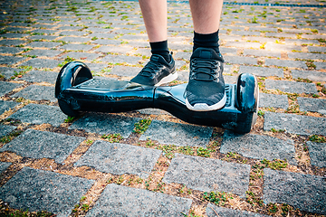 Image showing Teenager riding a hoverboard at schoolyard - self-balancing scooter, levitating board used for personal transportation