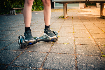 Image showing Teenager riding a hoverboard at schoolyard - self-balancing scooter, levitating board used for personal transportation