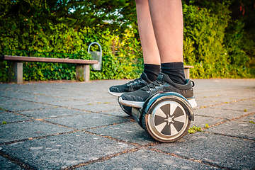 Image showing Teenager riding a hoverboard at schoolyard - self-balancing scooter, levitating board used for personal transportation