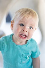 Image showing Portrait of cute little infant baby boy child playing on outdoor playground. Toddler plays on school or kindergarten yard.