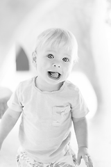 Image showing Black and white portrait of cute little infant baby boy child playing on outdoor playground. Toddler plays on school or kindergarten yard.