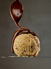 Image showing melted chocolate pouring on caramel ice cream