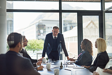 Image showing Presentation, man speaker with coworkers and in business meeting in a conference room of their workplace. Brainstorming or planning, ideas or data review and colleagues together in modern office