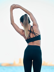 Image showing Back, exercise and woman stretching, beach and workout goal for wellness, meditation and health. Female person, girl and athlete stretch, seaside or break with fitness, training and yoga with peace