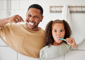 Image showing Child, father and brushing teeth in a family home bathroom for dental health. Face of happy african man and girl kid learning to clean mouth with toothbrush in mirror for morning routine or oral care