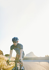 Image showing Training, bike and cycling with a sports man on a road through the mountain for cardio or endurance. Exercise, workout or fitness with a male cyclist riding his bicycle on an asphalt street in nature