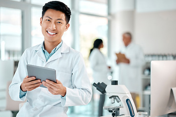 Image showing Tablet, asian man and portrait of a scientist in laboratory, hospital or science research for medicine, chemistry or innovation. Doctor, technology and medical worker with smile in clinic or lab