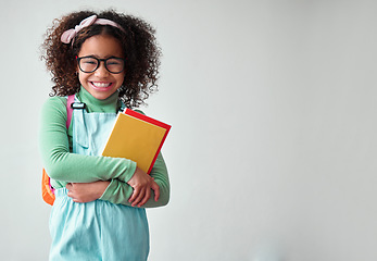 Image showing School, portrait of child student with books for knowledge, education and studying in a studio. Happy, smile and young smart girl kid with glasses for reading by a white background with mockup space.