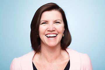 Image showing Happy, portrait of mature woman smile and against a blue background for health wellness. Happiness, mock up space and excited or cheerful female person smiling with pose against a studio backdrop