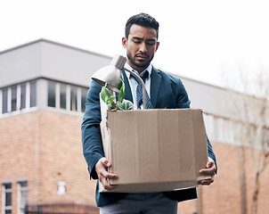 Image showing Economy, dismissal and a fired business man carrying a box while walking outdoor in the city. Financial depression, unemployment and jobless with a young male employee looking sad in an urban town