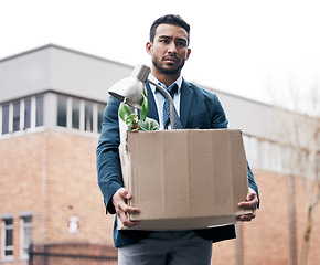 Image showing Box, recession and a fired business man walking outdoor in the city with stress of problem. Financial crisis, depression and unemployment with a young male employee looking sad in an urban street