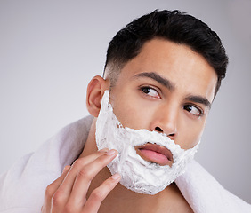 Image showing Shaving, cream and foam with face of man in studio for hair removal, beauty and skincare. Cosmetics, self care and morning with model and beard grooming on gray background for cleaning and product