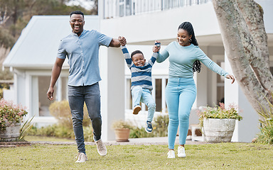 Image showing Happy parents lifting their kid by their new home in the outdoor garden while playing together. Backyard, bonding and African mother and father holding their boy child in the backyard of their house.