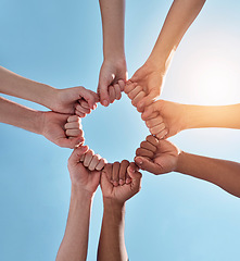 Image showing Diversity, fist pump and hands in a circle together for unity, collaboration and teamwork. Solidarity, empowerment and closeup of a group of multiracial people in a round shape by a sky background.