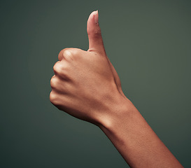 Image showing Thumbs up, hand gesture with emoji and agreement, person with approval and feedback isolated on green background. Yes, like and thank you, mockup space with OK sign and support closeup in studio