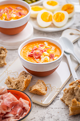 Image showing Salmorejo - raw tomato soup with ingredients on a kitchen table,