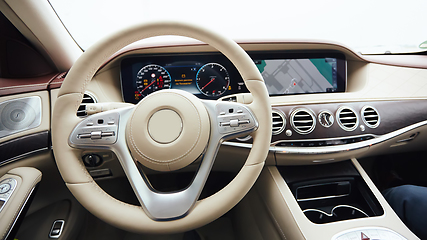 Image showing Car interior luxury. Interior of prestige modern car. Leather comfortable seats, dashboard and steering wheel. White cockpit with exclusive wood and metal decoration