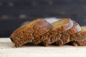 Image showing bread sliced on wooden cutting Board