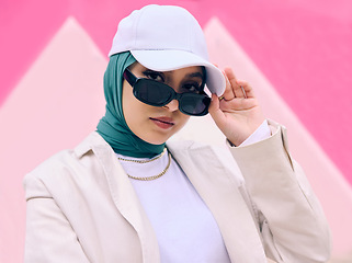 Image showing Muslim woman, fashion and sunglasses in portrait by wall, gen z aesthetic or beauty with art deco in city. Young islamic girl, student and clothes with pride, freedom or cap for travel in Dubai metro