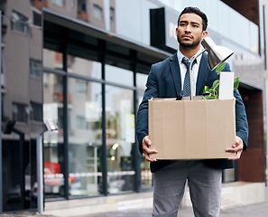 Image showing Depression, economy and box with a business man walking outdoor in the city for unemployment. Financial crisis, fired and jobless young male employee with failure, sad and stress in an urban street