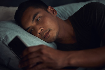 Image showing Dark, browse and man in bed with phone surfing internet, social media post or texting with insomnia in home. Wake up, scroll and male in bedroom with cellphone, mobile game and digital app at night.