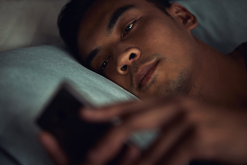 Image showing Night, bed and face of man with phone addiction, internet or social media, texting with insomnia in home. Wake up, online chat and male in dark bedroom with cellphone, mobile game and digital app.