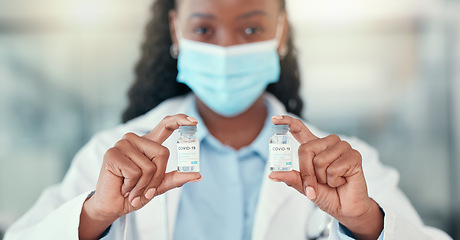 Image showing Covid 19, doctor hands and black woman with vaccine vial for virus or corona. Bottle, medical professional or portrait of person with vaccination mask, medicine or pharmaceutical drugs for healthcare