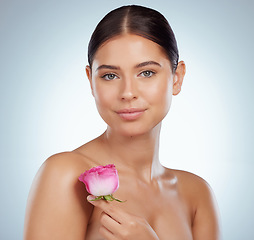 Image showing Skincare, face and woman with rose flower in studio isolated on a white background. Spring portrait, natural plant and female model with pink floral for makeup cosmetics, beauty treatment or wellness