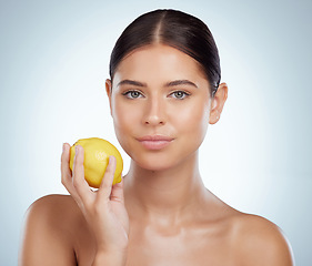 Image showing Face, skincare and woman with lemon in studio isolated on a white background. Portrait, natural fruit and serious female model with vitamin c, nutrition and healthy diet, wellness or beauty cosmetics