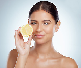 Image showing Face, skincare and woman with lemon in studio isolated on a white background. Portrait, natural or female model with fruit for vitamin c, vegan nutrition or healthy diet, wellness or beauty cosmetics