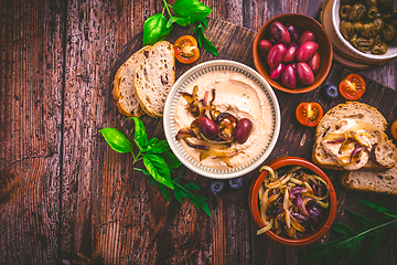 Image showing Whipped feta cheese dip with garlic, olives, lemon and carameliz