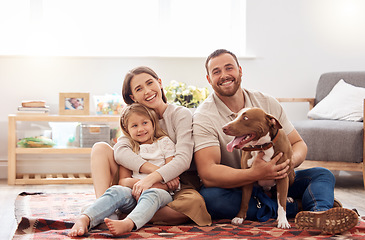 Image showing Mom, dad and portrait of kid with dog in living room for quality time, love and care together at home. Mother, father and happy family with child, pet pitbull and relax for happiness on carpet floor