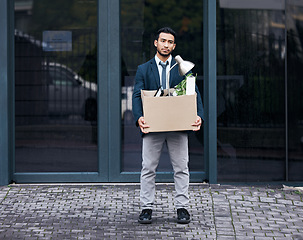 Image showing Depression, box and dismissal with a business man carrying while walking outdoor in the city. Financial crisis, economy unemployment and jobless with a fired male employee looking sad in the cbd