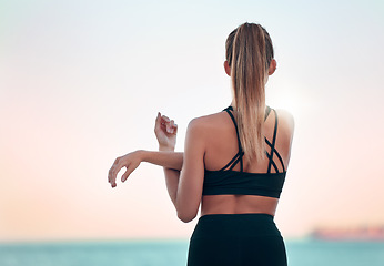 Image showing Stretching arm, back and woman at beach for yoga, exercise and ocean mockup space. Fitness, pilates and female athlete stretch for training, workout and health, wellness or warm up at summer sunset.